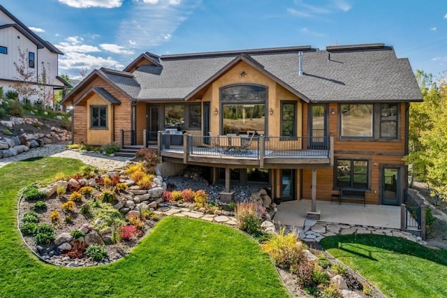 1138 Longview Cir, Steamboat Springs, CO 80487 - rear view of property with a patio, roof with shingles, a lawn, and a wooden deck