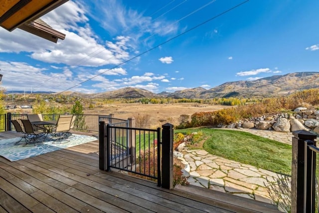 1138 Longview Cir, Steamboat Springs, CO 80487 - wooden terrace featuring outdoor dining area, a mountain view, and a lawn