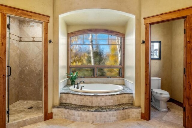 1138 Longview Cir, Steamboat Springs, CO 80487 - bathroom featuring a bath, a shower stall, toilet, and tile patterned flooring