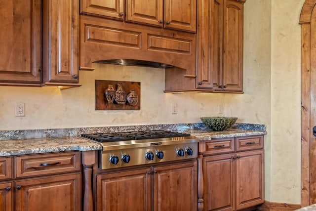 1138 Longview Cir, Steamboat Springs, CO 80487 - kitchen with stainless steel gas cooktop, brown cabinets, and light stone countertops