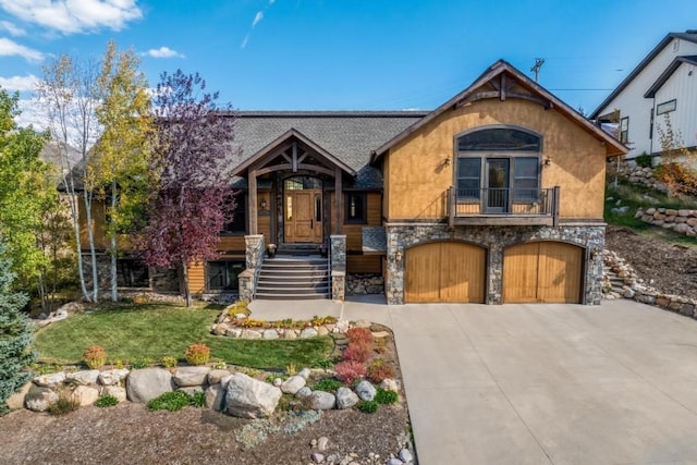 1138 Longview Cir, Steamboat Springs, CO 80487 - view of front of home with stone siding, a garage, concrete driveway, a balcony, and a front yard