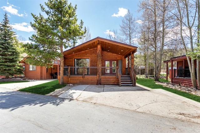 view of front of property with a porch and faux log siding