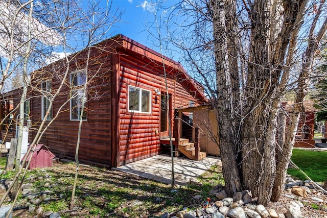 view of property exterior with entry steps and log veneer siding