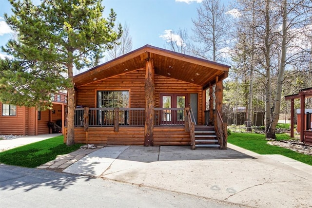 view of front of property with a porch and log veneer siding