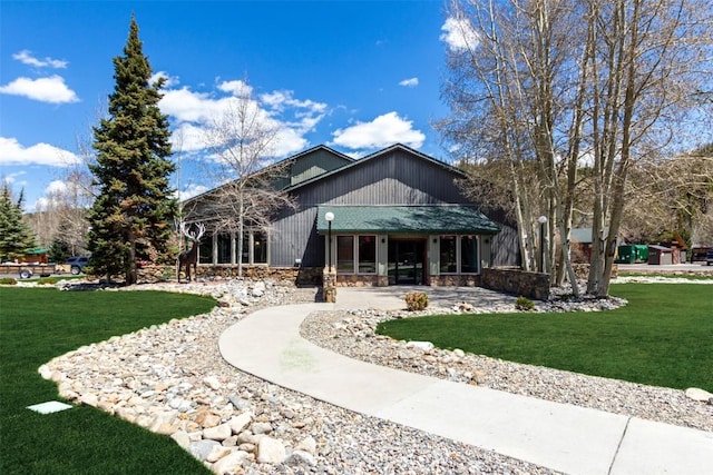 back of house with a yard and stone siding