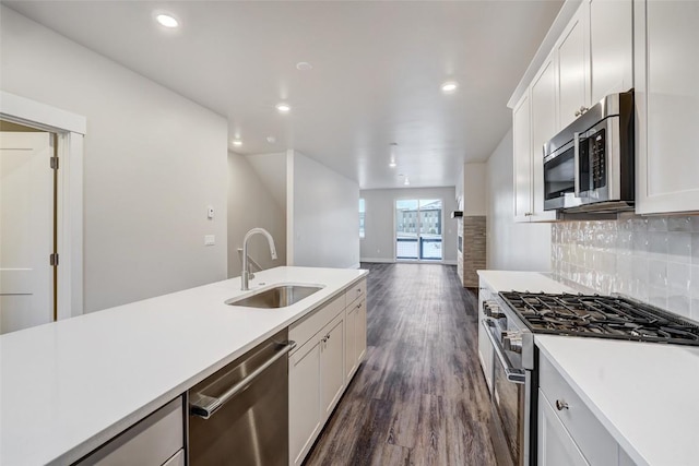kitchen with a sink, white cabinetry, light countertops, dark wood finished floors, and appliances with stainless steel finishes