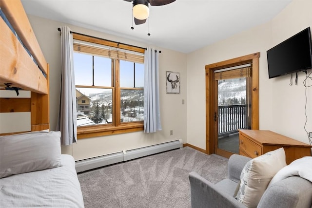 carpeted living room featuring baseboard heating, baseboards, and ceiling fan