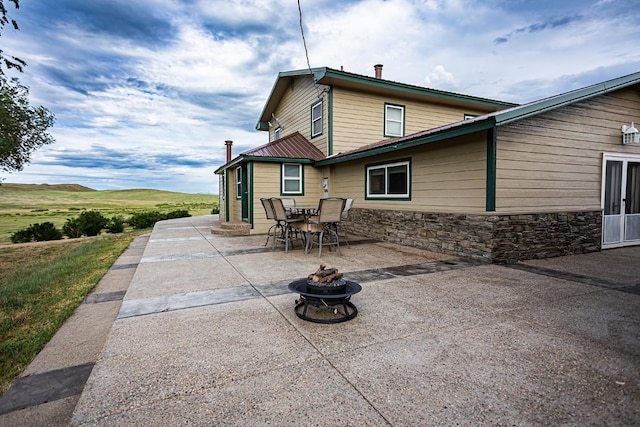 420 County Road 64, Craig, CO 81625 - back of property with a fire pit, a patio area, outdoor dining space, and stone siding