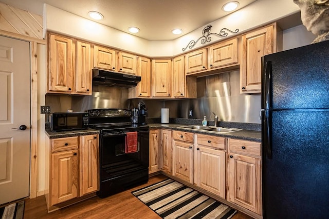 420 County Road 64, Craig, CO 81625 - kitchen with a sink, dark countertops, black appliances, under cabinet range hood, and dark wood-style floors