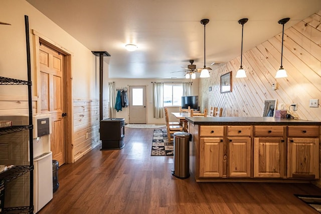 420 County Road 64, Craig, CO 81625 - kitchen with brown cabinets, dark wood-type flooring, ceiling fan, wooden walls, and dark countertops