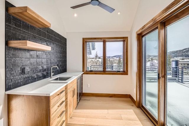 kitchen featuring lofted ceiling, a mountain view, sink, and decorative backsplash