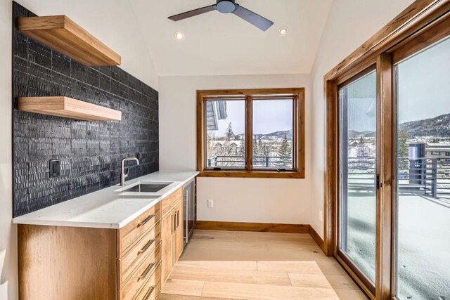 kitchen featuring a mountain view, sink, lofted ceiling, and decorative backsplash