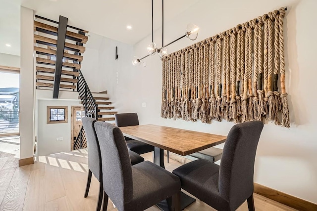 dining area featuring a notable chandelier and light wood-type flooring