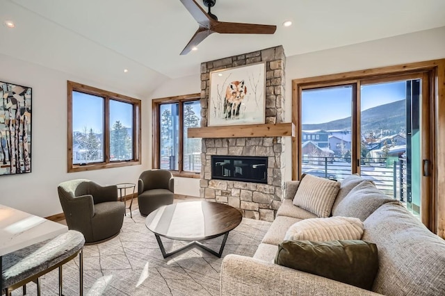 living room featuring a mountain view, vaulted ceiling, a fireplace, and ceiling fan