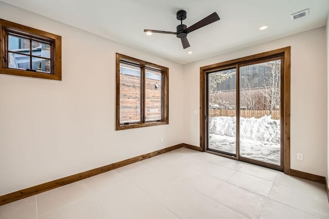 tiled spare room featuring ceiling fan