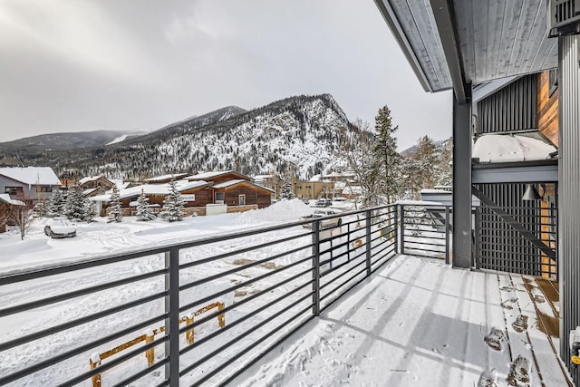 snow covered back of property featuring a mountain view