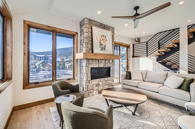 living room with lofted ceiling, a mountain view, ceiling fan, a fireplace, and light hardwood / wood-style floors