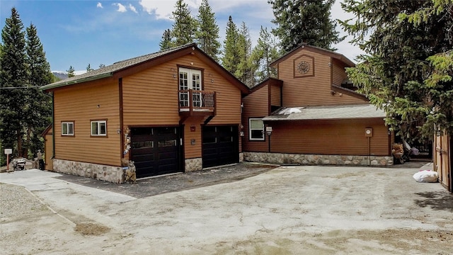 14 Rock Springs Rd, Breckenridge, CO 80424 - view of front of property featuring a garage, a balcony, stone siding, and driveway