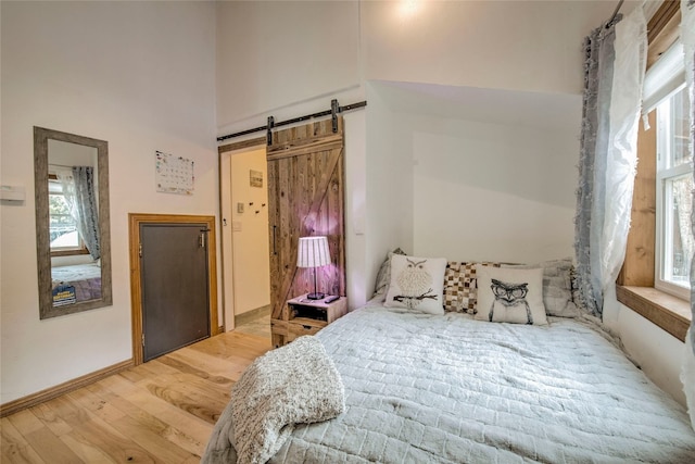 14 Rock Springs Rd, Breckenridge, CO 80424 - bedroom featuring wood finished floors, a barn door, baseboards, and a towering ceiling