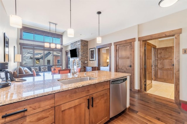 kitchen with a sink, brown cabinetry, dishwasher, decorative light fixtures, and wood-type flooring