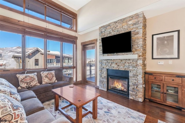 living area featuring a towering ceiling, wood finished floors, and a fireplace
