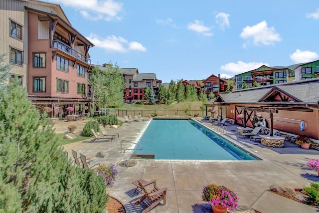 pool with fence, a residential view, and a patio