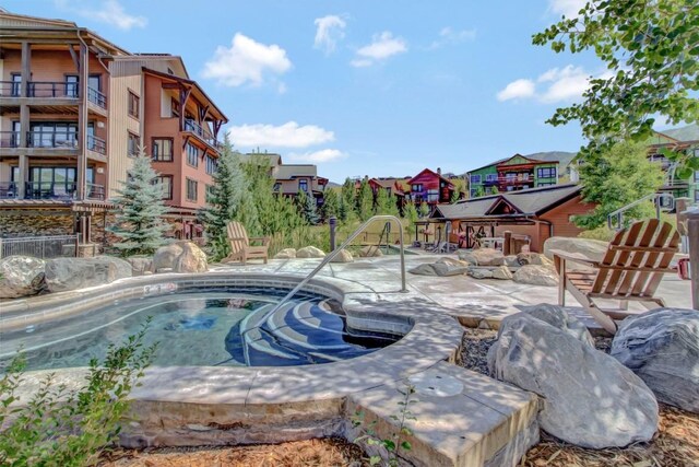 view of pool with a hot tub and a residential view