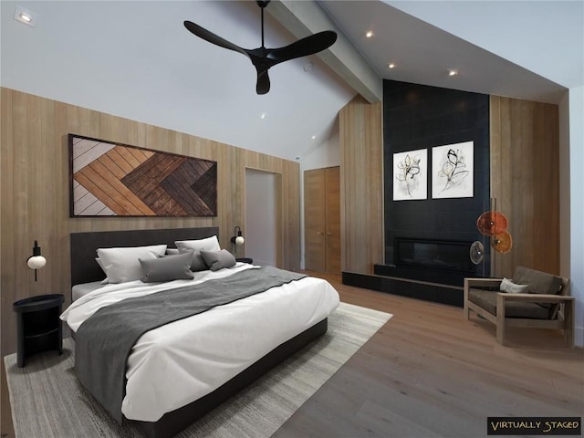 bedroom with ceiling fan, lofted ceiling with beams, and wood walls