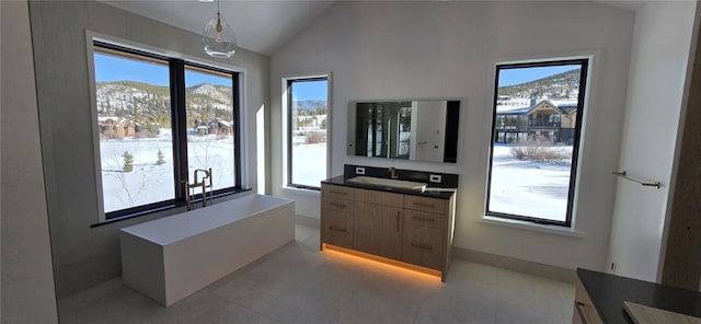 bathroom featuring vanity, plenty of natural light, lofted ceiling, and a mountain view