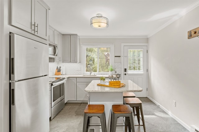 67 Peaks View Ct Unit 232, Blue River, CO 80424 - kitchen featuring appliances with stainless steel finishes, a kitchen breakfast bar, decorative backsplash, crown molding, and light stone counters