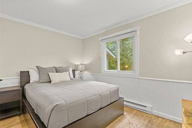 67 Peaks View Ct Unit 232, Blue River, CO 80424 - bedroom featuring baseboard heating, crown molding, a wainscoted wall, and light wood-style floors