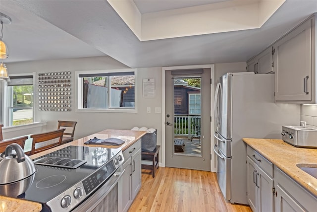 211 S High St, Breckenridge, CO 80424 - kitchen featuring gray cabinets, appliances with stainless steel finishes, light stone countertops, and light wood-style floors