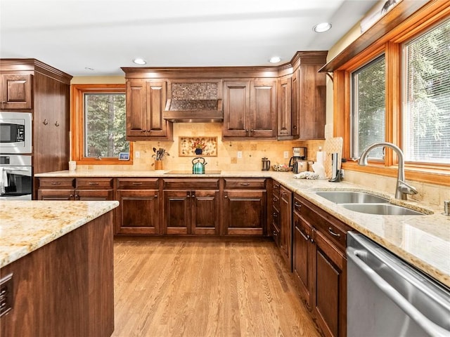 50 Sunset Dr, Breckenridge, CO 80424 - kitchen featuring stainless steel appliances, premium range hood, light wood-style flooring, light stone counters, and decorative backsplash