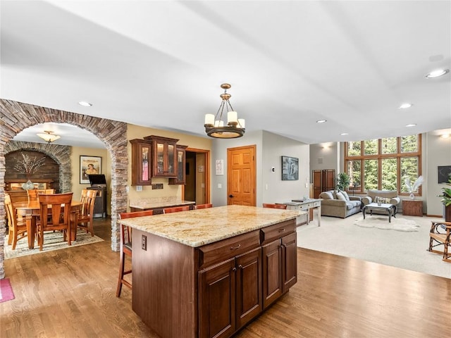 50 Sunset Dr, Breckenridge, CO 80424 - kitchen featuring a kitchen island, arched walkways, glass insert cabinets, hanging light fixtures, and recessed lighting