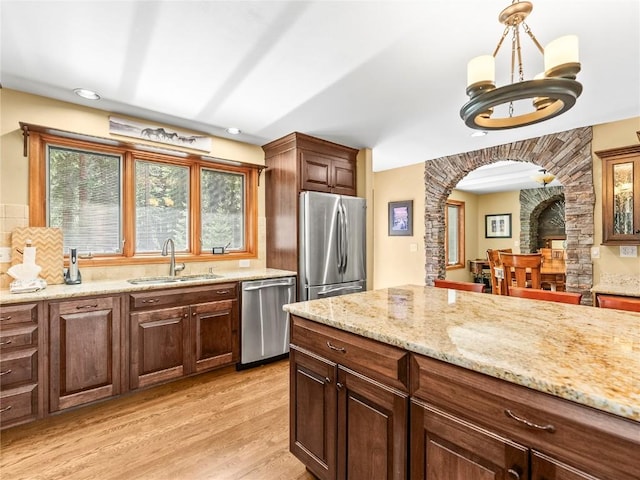 50 Sunset Dr, Breckenridge, CO 80424 - kitchen with stainless steel appliances, arched walkways, light wood finished floors, decorative backsplash, and light stone counters