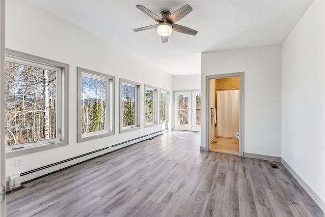 interior space featuring light hardwood / wood-style floors, ceiling fan, and a baseboard heating unit