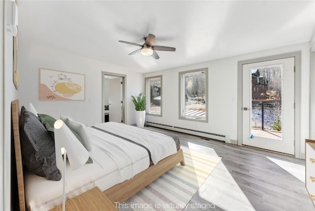 bedroom featuring baseboard heating, ceiling fan, light wood-type flooring, and access to outside