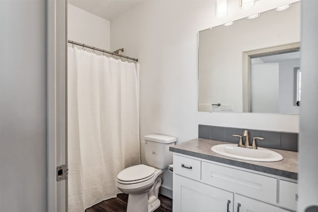 bathroom with walk in shower, hardwood / wood-style floors, vanity, and toilet