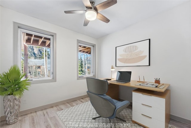 home office featuring light wood-type flooring, plenty of natural light, and ceiling fan