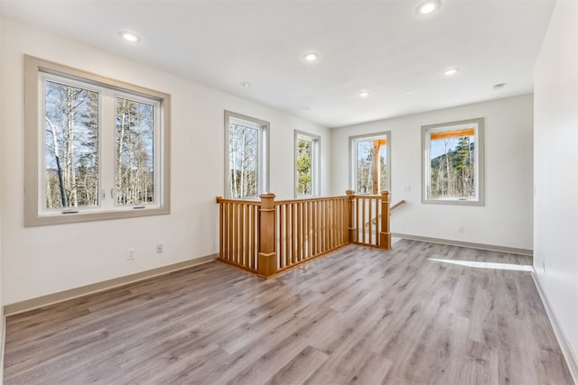 spare room featuring a healthy amount of sunlight and light hardwood / wood-style flooring