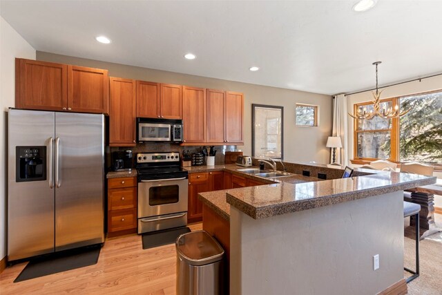 73 Chestnut Ln Unit 73, Breckenridge, CO 80424 - kitchen featuring tile counters, a sink, a chandelier, a breakfast bar area, and appliances with stainless steel finishes