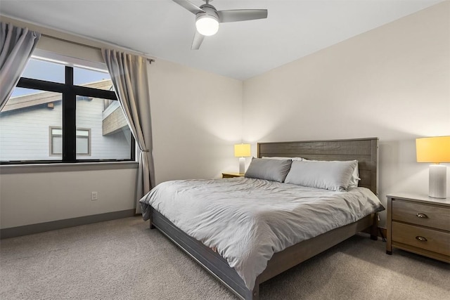 bedroom featuring light colored carpet, ceiling fan, and baseboards