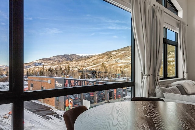 snow covered back of property with a mountain view