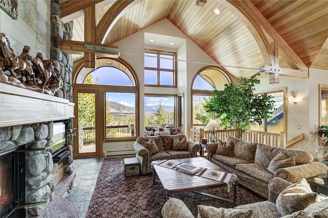348 Jade Rd, Silverthorne, CO 80498 - living room with wood ceiling with exposed beams, high vaulted ceiling, a stone fireplace, stone tile floors, and a mountain view