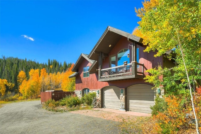 348 Jade Rd, Silverthorne, CO 80498 - view of front facade with a balcony, dirt driveway, and a forest view