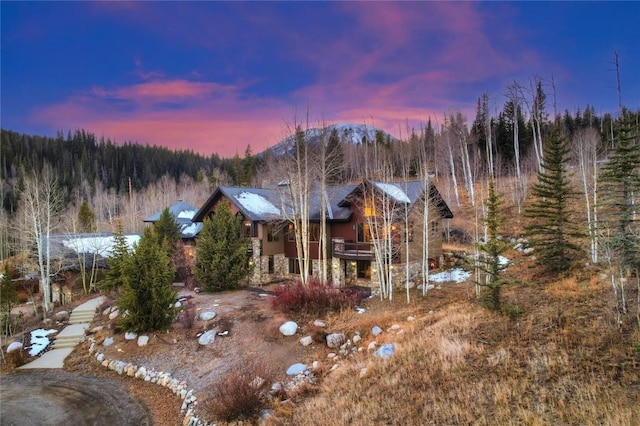 348 Jade Rd, Silverthorne, CO 80498 - back of property at dusk featuring a wooded view