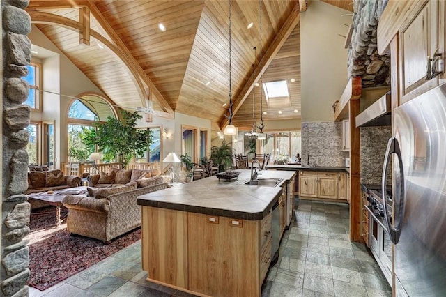 348 Jade Rd, Silverthorne, CO 80498 - kitchen featuring stainless steel appliances, stone tile flooring, high vaulted ceiling, a sink, and an island with sink
