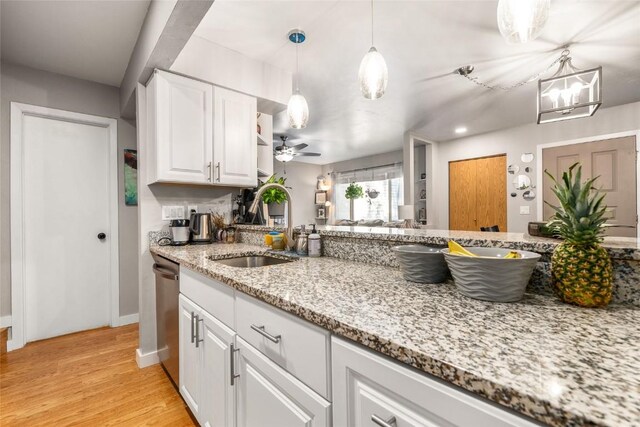 26 Cypress Ct Unit 26, Steamboat Springs, CO 80487 - kitchen featuring a sink, pendant lighting, light wood finished floors, white cabinetry, and light stone countertops
