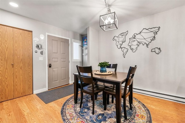 26 Cypress Ct Unit 26, Steamboat Springs, CO 80487 - dining area featuring light wood-type flooring, baseboards, a chandelier, and a baseboard heating unit
