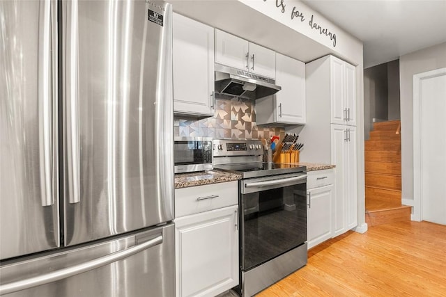 26 Cypress Ct Unit 26, Steamboat Springs, CO 80487 - kitchen featuring decorative backsplash, light wood-type flooring, appliances with stainless steel finishes, white cabinetry, and under cabinet range hood